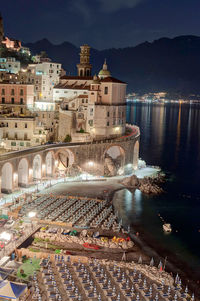 High angle view of illuminated buildings by river at night