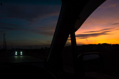 Silhouette road against sky during sunset