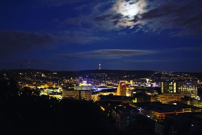 Illuminated cityscape against sky at night