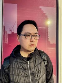 Portrait of young man standing against wall