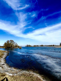 Scenic view of lake against sky during winter