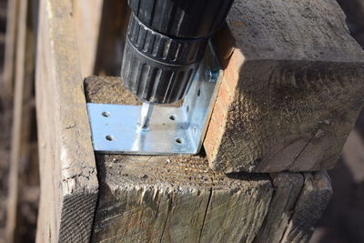 High angle view of drill machine on metal over wood