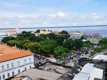 High angle view of townscape by sea against sky