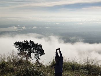 Rear view of woman standing against sky