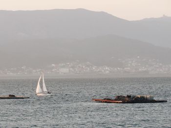 Sailboat sailing on sea against sky