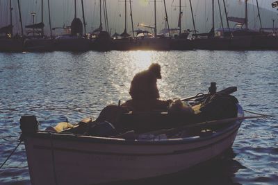 Rear view of woman sitting on sailboat in sea
