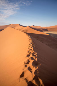 Sand dunes in desert against sky