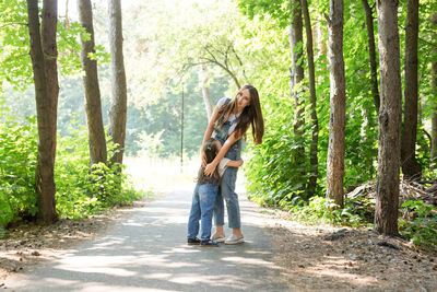 Friends standing by tree in forest