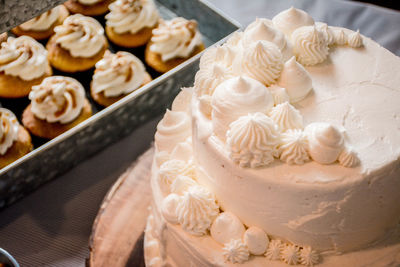 High angle view of cupcakes and wedding cake on table