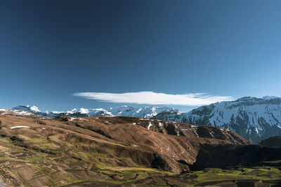 Scenic view of snowcapped mountains against blue sky