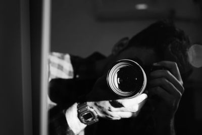 Midsection of person holding camera at home