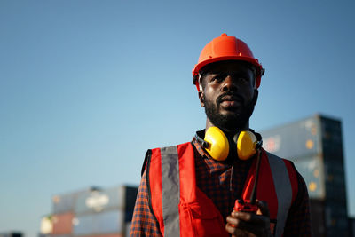 Low angle view of engineer against sky