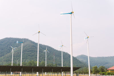 Wind turbines on landscape against sky