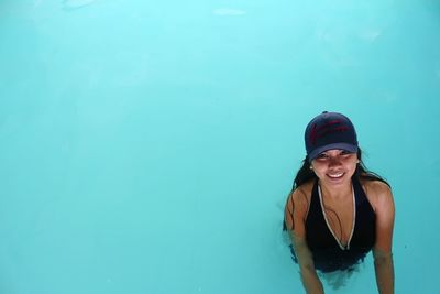 Portrait of smiling young woman standing in swimming pool