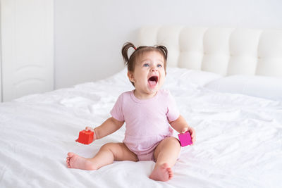 Cute baby boy lying on bed at home