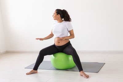 Full length of woman sitting on floor