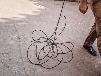 Low section of man walking by wire on street
