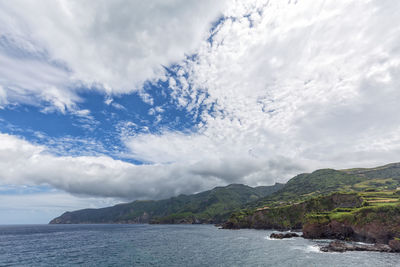 Scenic view of sea and mountains against sky