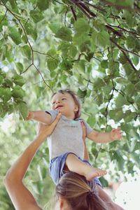 Full length of woman looking at tree