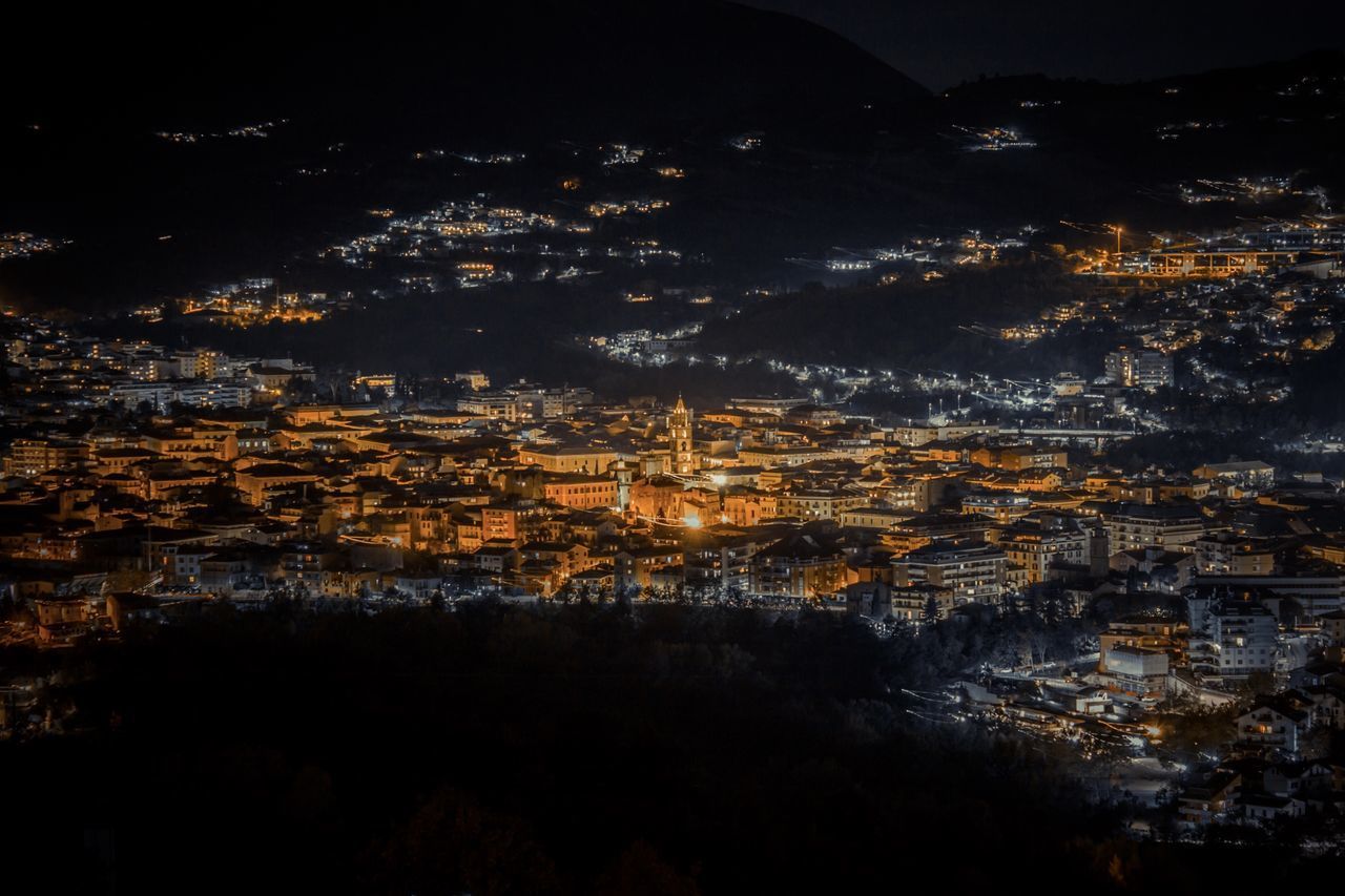 HIGH ANGLE VIEW OF ILLUMINATED BUILDINGS IN CITY AGAINST SKY