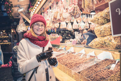 Portrait of smiling young woman in market during winter