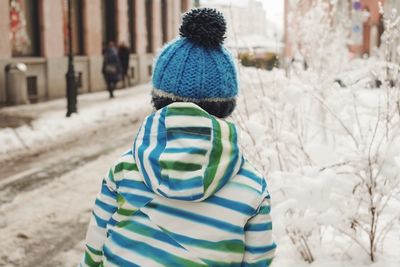 Rear view of person walking on snow