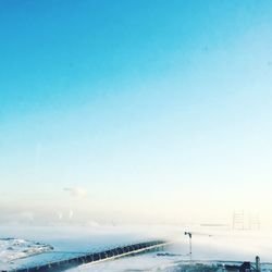 Scenic view of snow against clear blue sky