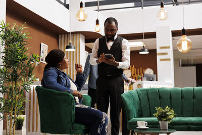 Side view of man using mobile phone while sitting at home