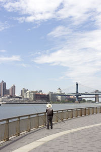 Rear view of man on bridge against sky