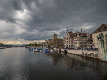 View of town by sea against cloudy sky