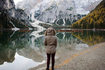 Rear view of woman standing by lake