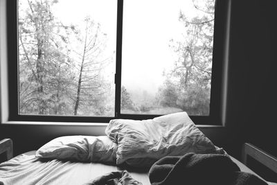 Man sleeping on bed by window