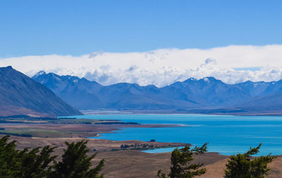 Scenic view of sea and mountains against blue sky