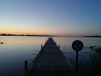 Scenic view of lake against clear sky at sunset