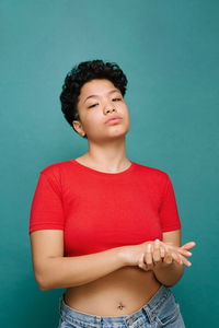 Mid adult woman standing against blue background