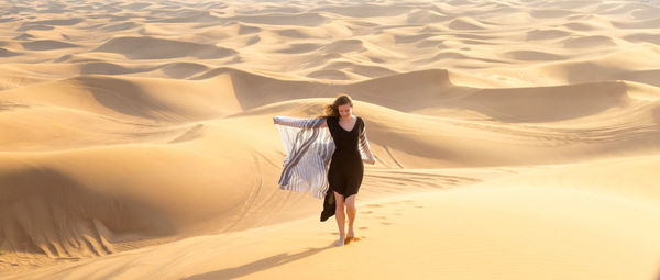 Full length of woman walking at desert