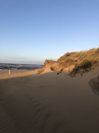 Scenic view of beach against clear blue sky