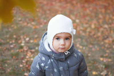 Portrait of cute little caucasian girl on background of autumn leaves.