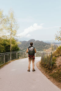 Rear view of man on road against sky