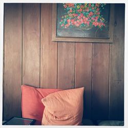 Pillows on against wooden wall at home