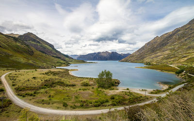 Scenic view of lake amidst mountains against cloudy sky