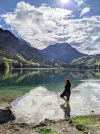 Man standing on lake against mountains
