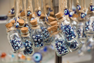 Close-up of beads in bottles hanging at market