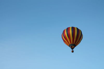 Low angle view of hot air balloon against clear blue sky