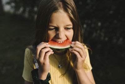 Portrait of young woman eating fruit