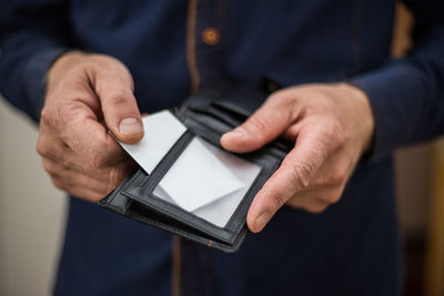 Midsection of man holding placard in wallet