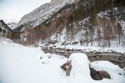 Snow covered rocks against mountain