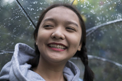 Portrait of smiling young woman in rain