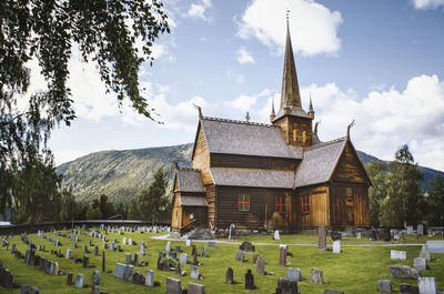Panoramic view of cemetery and buildings against sky
