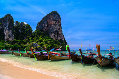 Boats moored on beach against sky